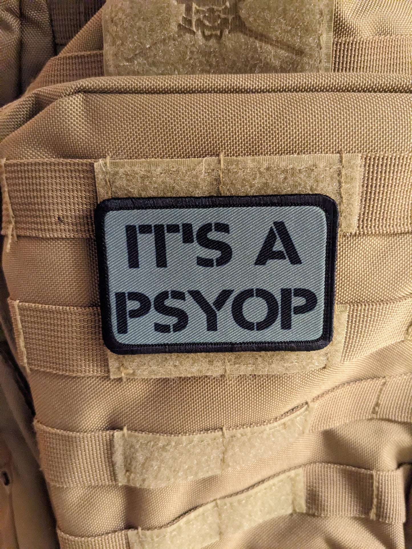 It's a Psyop conspiracy joke gray 2"x3" morale patch with hook and loop backing