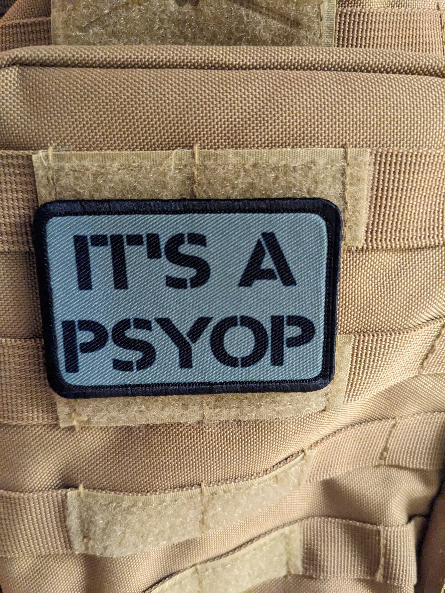 It's a Psyop conspiracy joke gray 2"x3" morale patch with hook and loop backing