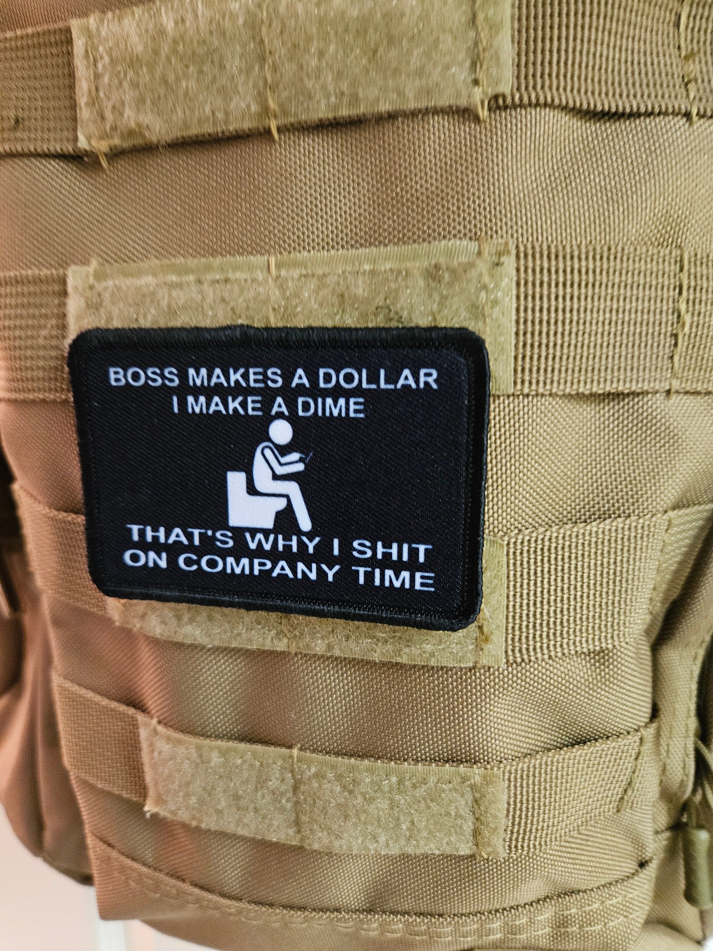 Boss makes a dollar I make a dime that's why I shit on company time 2"x3" morale patch with hook and loop backing black