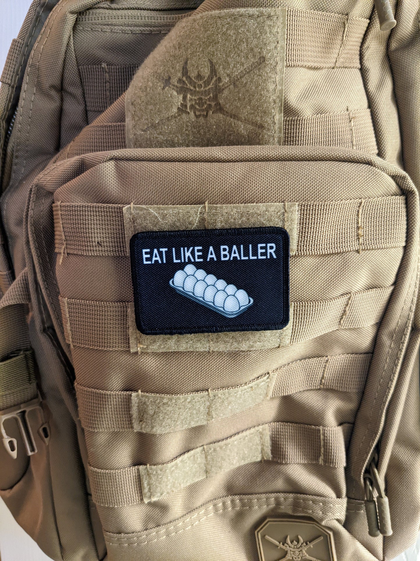Eat like a baller egg shortage inflation meme  2"x3" removable morale patch with hook and loop backing